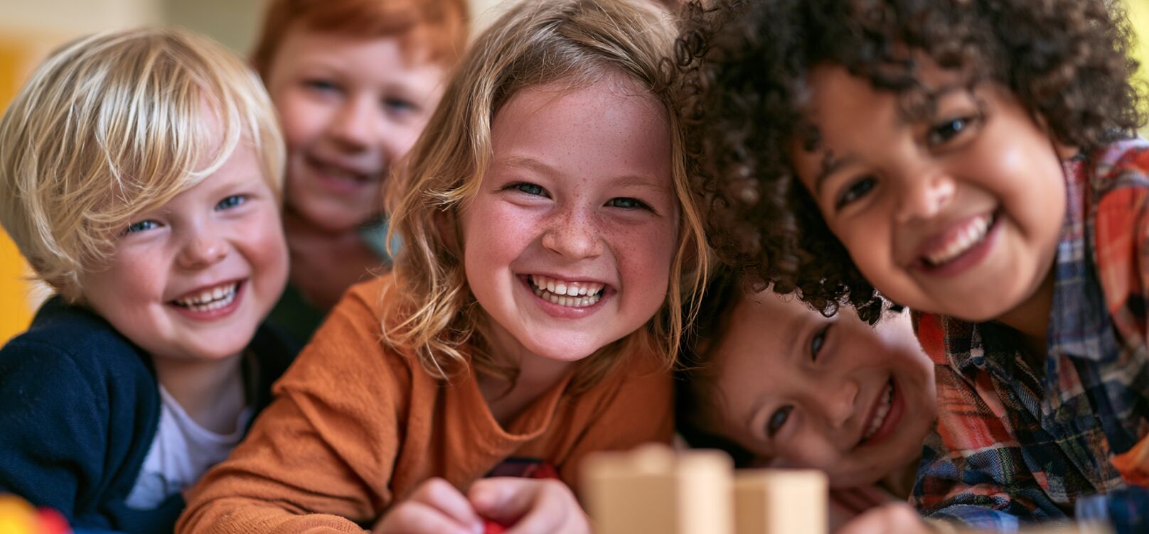 Smiling children gathered around a table at a daycare
